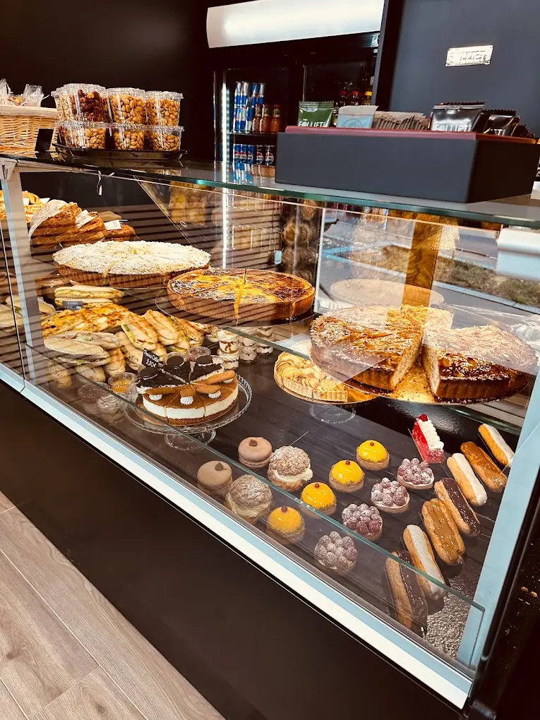 La vitrine de pâtisseries : tartes, éclairs, petits gâteaux aux fruits et sandwichs sur plusieurs étagères